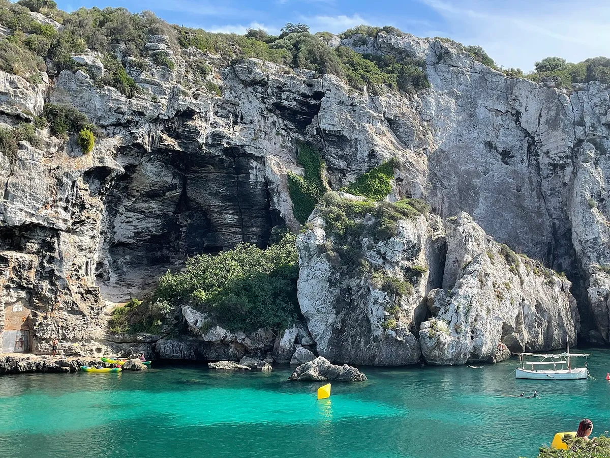 Glass-bottomed catamaran cruising the harbour of Mahon in Menorca, the entry tier of the are boat trips in Menorca worth it question
