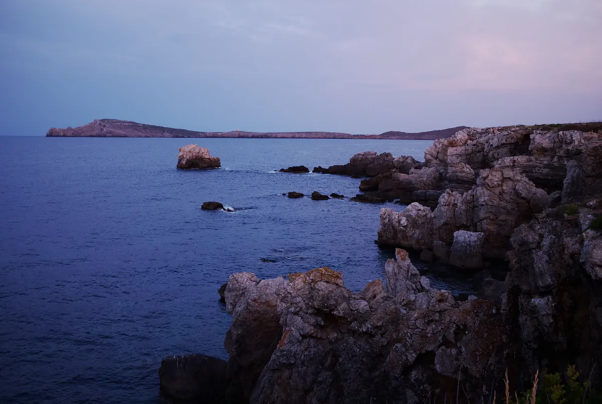 Cap de Cavalleria headland above the Menorca marine reserve, the western gate of the waters crossed on a menorca marine reserve boat trip