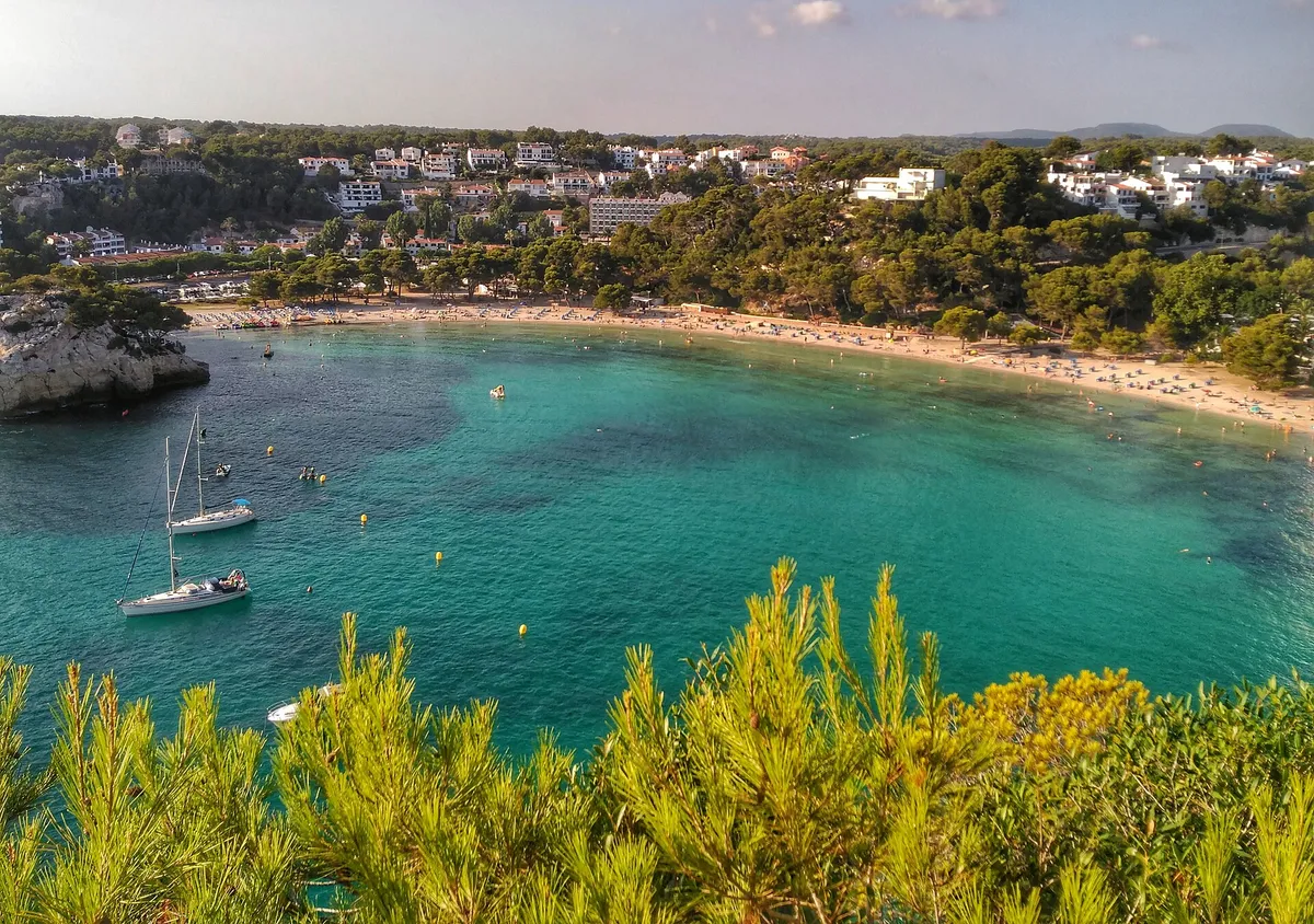 Beach boarding point at Cala Galdana in Menorca where south coast boat excursions take passengers aboard barefoot through shallow water