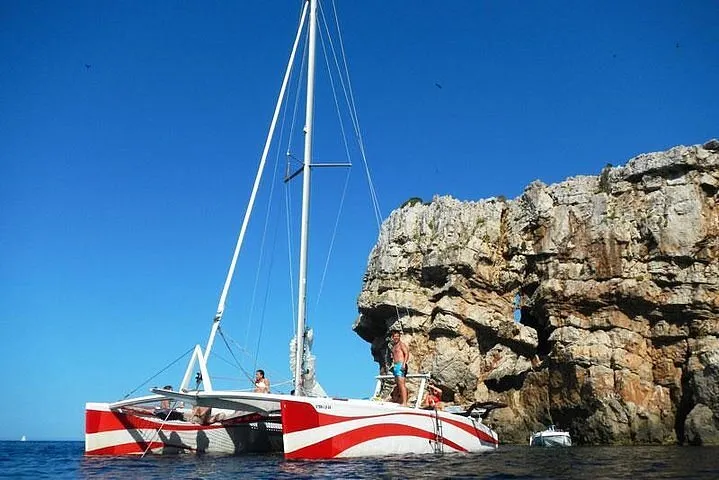Private sailing catamaran chartered by one group anchored in a clear cove of northern Menorca's marine reserve